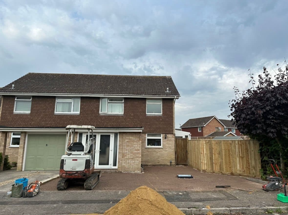 Driveway excavated to bare ground with a mini-digger and pile of sand