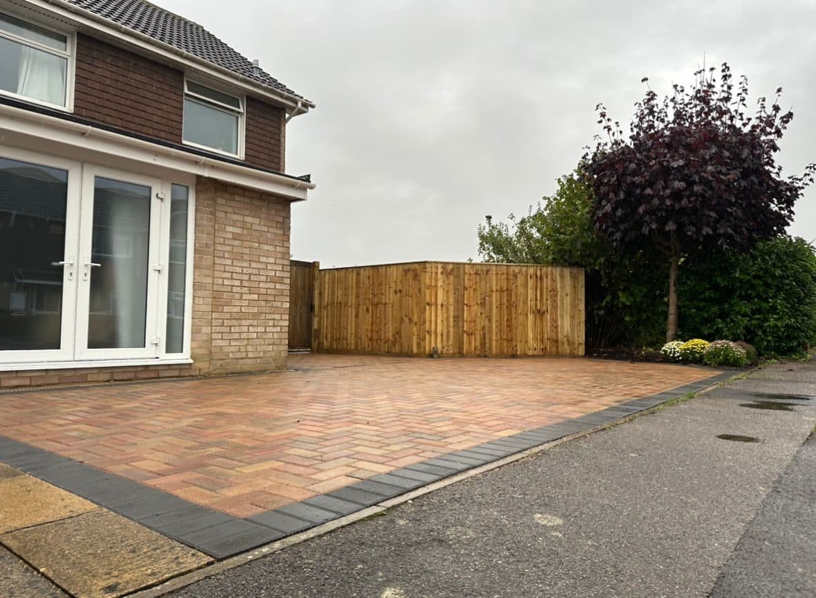 Finished brindle block-paving driveway with a charcoal border and timber fence